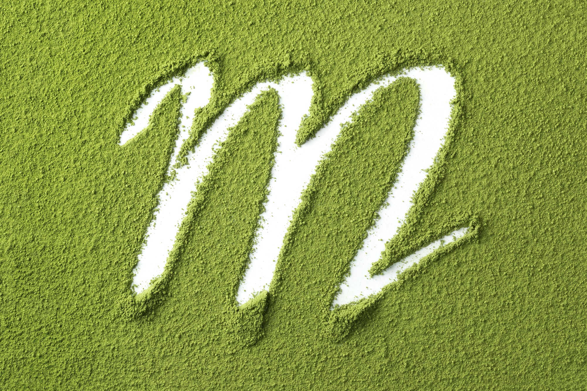 Green Japanese Matcha tea powder full frame and the letter M